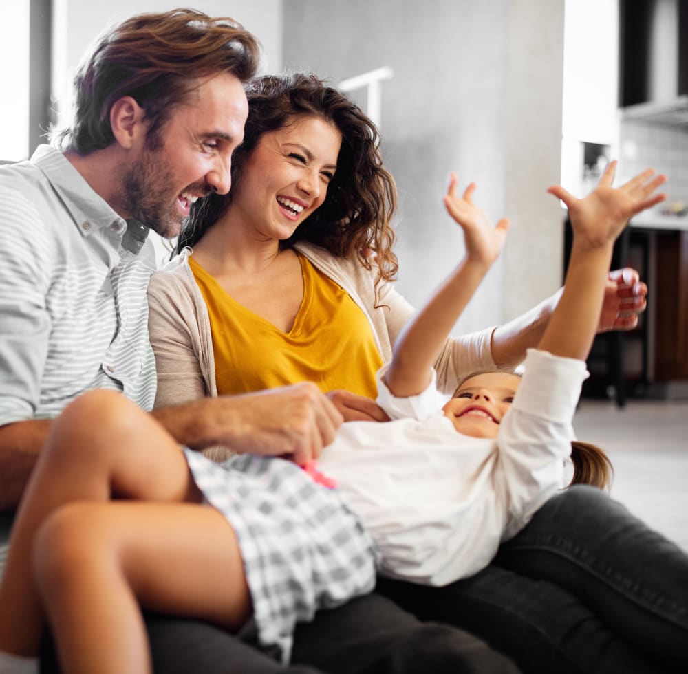 Parents laughing with their daughter.